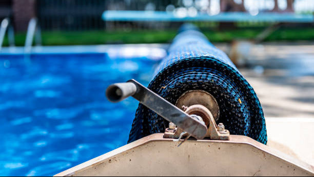 Blue pool cover rolled up with ratchet